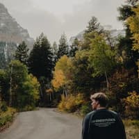 Outdoor photograph of Hunter Bastian walking along a mountain road.
